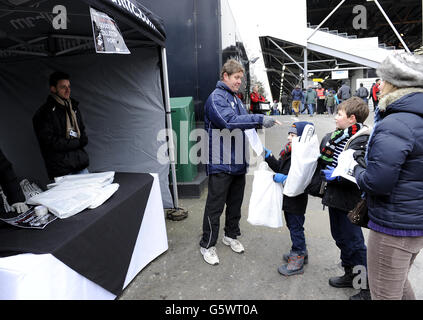 Young Fulham fans receive their foam fingers and goody bags outside the Putney End Stock Photo