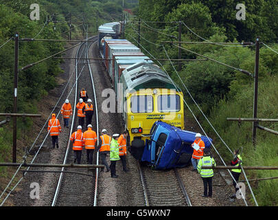 Investigators and emergency service personnel inspect the scene at Lawford, near Manningtree, Essex, after a freight train smashed, into the cab of a lorry that had overturned and separated from the main chassis of the vehicle. * A British Transport Police spokesman said the driver of the lorry was hurt in the incident, although it was not immediately clear how seriously. Local people who went to the scene near Manningtree, Essex, said the emergency services were called after the lorry ended up on the track. But the train then arrived and crashed into the part of the lorry that had fallen on Stock Photo