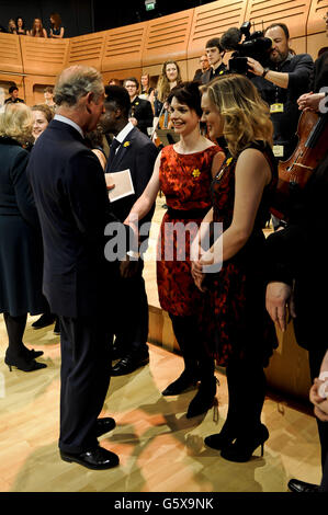 The Prince of Wales greets Catrin Finch, who was the first harpist to the Prince, with Hannah Stone (right), current harpist to the Prince, in the Dora Stoutzker Hall at the Royal Welsh College of Music and Drama, Cardiff, Wales. Stock Photo