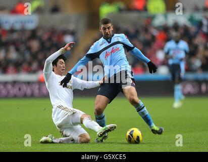 Soccer - Barclays Premier League - Swansea City v Queens Park Rangers - Liberty Stadium. Queens Park Rangers' Adel Taarabt (right) and Swansea City's Sung-Yeung Ki (left) battle for the ball Stock Photo