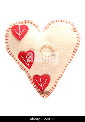 Engagement ring on a heart pillow cutout Stock Photo