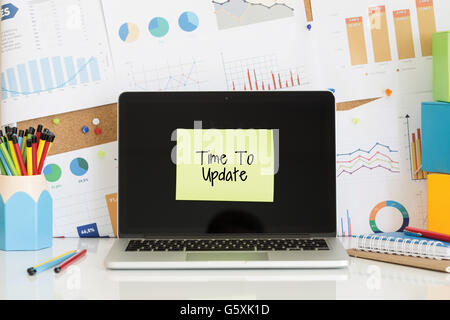 TIME TO UPDATE sticky note pasted on the laptop screen Stock Photo