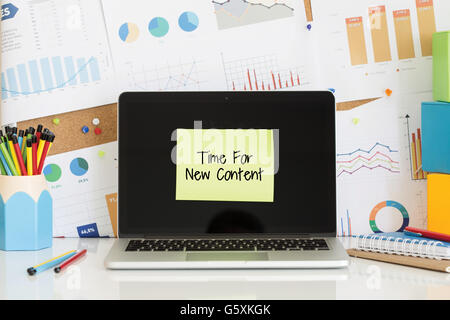 TIME FOR NEW CONTENT sticky note pasted on the laptop screen Stock Photo