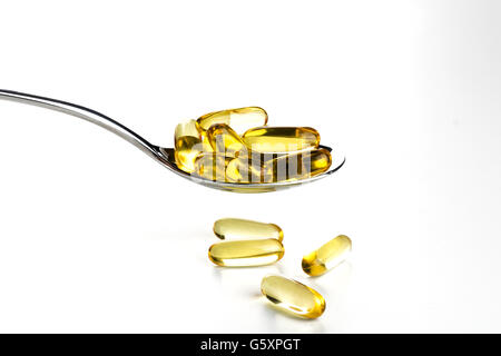 Spoonful of gel capsules of omega 3 Stock Photo