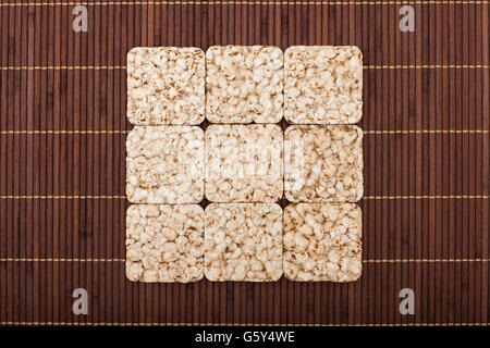 Square composition of nine crunchy rye crispbreads on bamboo napkin Stock Photo
