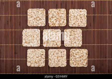 Composition of square nine crunchy rye crispbreads on bamboo napkin Stock Photo