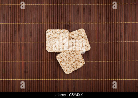 Composition of square three crunchy rye crispbreads on bamboo napkin Stock Photo