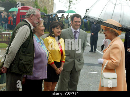 Britain's Queen Elizabeth II chats to actors (l-r) Stan Richards (Seth Armstrong), Paula Tilbrook (Betty Eggleston), Deena Payne (Viv Hope) and Antony Audenshaw (Bob Hope) during a visit to the set of the Yorkshire Soap opera, Emmerdale, on her Golden Jubilee tour of Britain. * The Queen arrived at the programme makers' permanent set at the Harewood House estate near Leeds to witness the village post office going up in flames. Stock Photo