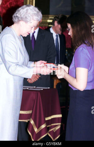 Queen Elizabeth II presenting a bronze medal to Helen Nightingale, aged 17, from Henley College, Henley-on-Thames Oxforshire, who was a winner in the Queen's Golden Jubliee poetry competition. * Some 4,000 children from England, Wales, Scotland and Northern Ireland entered the competition and the winners were invited to Buckingham palace for the presentation. Stock Photo