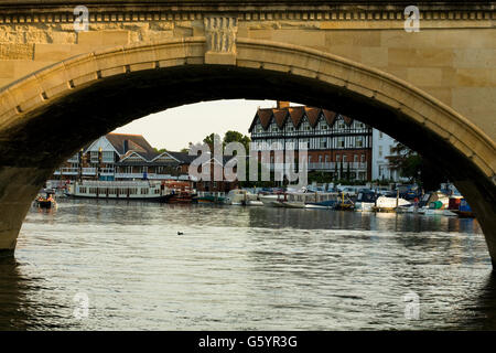 looking through the arch of Henley Bridge from a boat towards boats and building on the other side Stock Photo