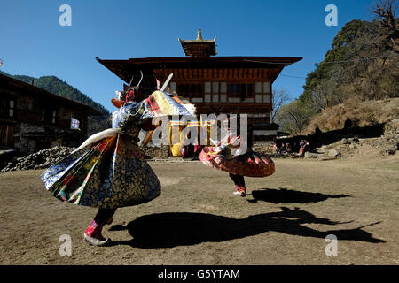 Masked dancers taking part in a rare and old sacred dance called Zhey not performed elsewhere in Bhutan during the annual religious Bhutanese Tshechu festival in Ngang Lhakhang a Buddhist monastery also known as the 'Swan temple' built in the 16th century by a Tibetan lama named Namkha Samdrip in the Choekhor Valley of Bumthang District central Bhutan Stock Photo