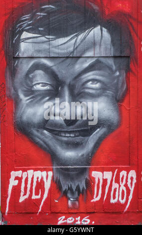 A wall art painting of a mans face on a red background. Stock Photo