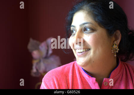 young indian lady smiling light on her face Model Release Stock Photo