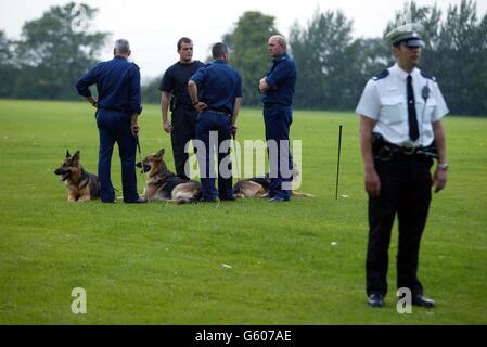 Police dog team search the playing fields of Soham Village College while police question the caretaker and his partner over the missing 10-year-old girls Jessica Chapman and Holly Wells in Soham Cambridhgeshire. Stock Photo