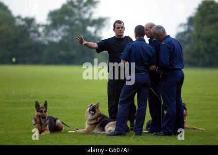 Police dog team search the playing fields of Soham Village College while police question the caretaker and his partner over the missing 10-year-old girls Jessica Chapman and Holly Wells in Soham Cambridhgeshire. Stock Photo