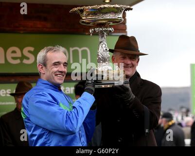 Jockey Ruby Walsh (left) and trainer Willie Mullins lift the trophy after Hurricane Fly wins the Stan James Champion Hurdle Challenge Trophy during day one of the 2013 Cheltenham Festival at Cheltenham Racecourse, Gloucestershire. Stock Photo