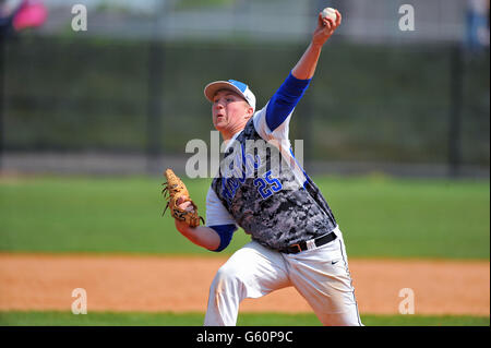 Left-handed pitcher delivering a pitch to a waiting hitter during a high school baseball game. USA. Stock Photo