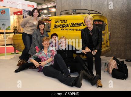 Members of the Public pose for a photograph in front of the Trotters' Reliant Robin at the 'Only Fools and Horses' Re-fit with George Clarke exhibition stand at the Ideal Home Show 2013 at Earls Court, London. Stock Photo
