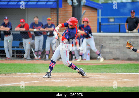 A high school batter making contact during a regular season varsity baseball game. USA. Stock Photo