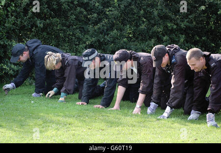 A Police search team carry out a fingertip search for clues about the missing 10-year-olds Holly Wells and Jessica Chapman who went missing from their homes in Soham, Cambridgeshire on Sunday. Stock Photo