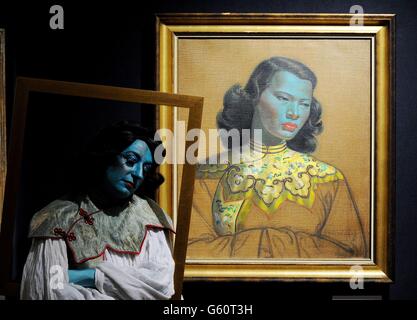 Cabaret artist Tricity Vogue whose act 'Blue Lady' is inspired by South African settled Russian artist Vladimir Tretchikoff, as she stands next to his work 'Chinese Girl' which will go on sale during Bonhams' South African art sale on March 20th and will be sold for an estimated £300,000 to £500,00. Stock Photo