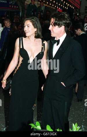 Actor Hugh Grant arrives with actress girlfriend Elizabeth Hurley for the charity premiere of 'Four Weddings and a Funeral' in which he stars. Stock Photo