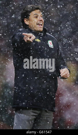 Soccer - FIFA World Cup 2014 Qualifying - Group A - Scotland v Wales - Hampden Park. Wales' manager Chris Coleman directs his players through the snow during the 2014 World Cup Qualifier at Hampden Park, Glasgow. Stock Photo