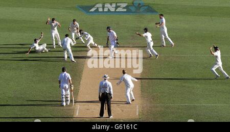 New Zealand's Tim Southee (left) celebrates taking the catch of England's Steven Finn (top centre) during day four of the Third Test match at Eden Park, Auckland, New Zealand. Stock Photo