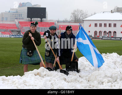 Scotland fan Dougie McKinlay (c) with his friends helping to clear snow from the pitch in the stadium before the FIFA World Cup Qualifying, Group A match at Karaorde Stadium, Novi Sad, Serbia. Stock Photo