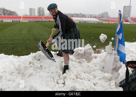 Scotland fan Dougie McKinlay helping to clear snow from the pitch in the stadium before the FIFA World Cup Qualifying, Group A match at Karaorde Stadium, Novi Sad, Serbia. Stock Photo