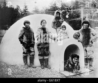 Inuit couples and children outside a fake igloo at the Alaska-Yukon-Pacific Exposition, in Seattle, Washington in 1909. The Exposition was a world's fair held to publicise the development of the Pacific Northwest after the Klondike Gold Rush. Photo by Otto D. Goetze, October 1909. Stock Photo