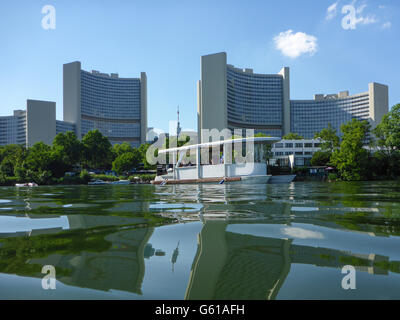 party boat in lake Kaiserwasser of the Old Danube in front of UNO City ( Vienna International Center ), Wien, Vienna, Austria, W Stock Photo