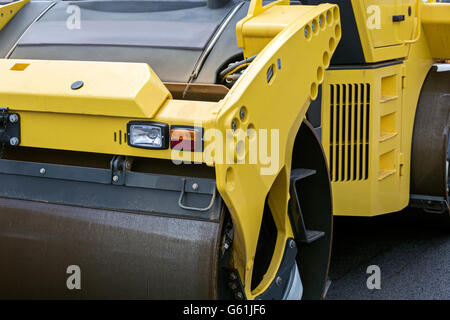 Large steam roller paving a new asphalt road Stock Photo