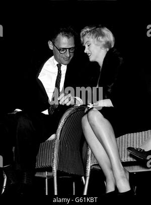 Film star Marilyn Monroe leans over to whisper confidentially to her playwright husband, Arthur Miller, at a meeting concerning the re-opening of the New Watergate Theatre Club, held at the Club's new venue, the Comedy Theatre, Panton Steet, London. CELEBRITY Stock Photo