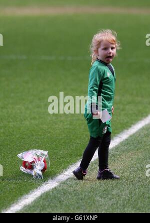 Grace Mealand aged 4 from Bootle lays flowers on the pitch at during the Hillsborough disaster memorial service, at Anfield, marking the 24th anniversary of the disaster, to remember the 96 Liverpool supporters who died in a crush at Sheffield Wednesday's Hillsborough stadium on April 15 1989 where their team were to meet Nottingham Forest in an FA Cup semi-final. Stock Photo