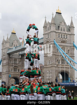 Members of the Human Towers Castellers de Vilafranca team form successively smaller tiers by climbing up the bodies of each layer to mount the shoulders of the previous tier until the tower is complete at Tower Bridge in London. A uniquely Catalan custom, the Human Towers have been constructed during town celebrations and festivals in Barcelona for three hundred years and are described by UNESCO as an Intangible Cultural Heritage of Humanity. Stock Photo