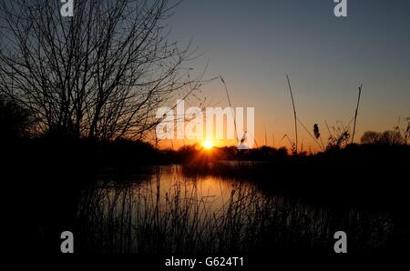 The sun sets over a fishing lake near Burton Upon Stather, North Lincolnshire. Stock Photo