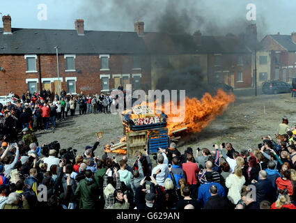 Protesters set fire to a coffin containing an effigy of Margaret Thatcher after a protest march on the day of her funeral. Stock Photo