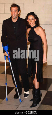 British tennis Player Greg Rusedski arrives on crutches with his wife Lucy for a private view of the Versace at the V&A exhibition at the Victoria and Albert Museum in London. Stock Photo