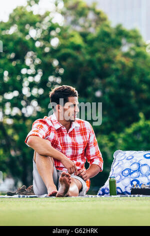 Young handsome man relaxing in park playing chess Stock Photo