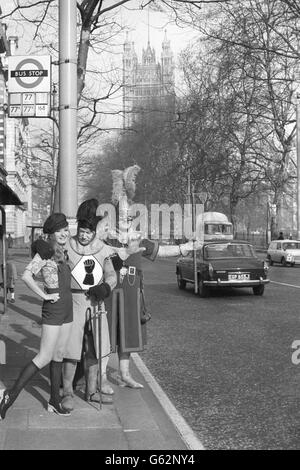 A knight in jousting armour, Max Diamond, Champion Knight of Middlesex, with model Gail Miller, 26, and TV stuntman and Champion of Kent, Nosher Powell (r), stood at a Westminster bus stop. Both knights will be taking part in a three-day jousting tournament at the National Exhibition of Gardening in Syon Park, Brentford, over Easter. Stock Photo