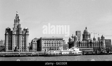 Royal Liver Building in Liverpool, left, with the Mersey ferry on its way along the River Mersey. Stock Photo