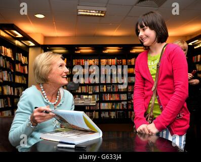 Mary Berry signs a copy of her book 'At Home' for a young fan, at a book signing session in a Waterstone's Book shop in Kensington, west London. Stock Photo