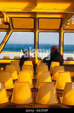 Graphic photograph of 2 passengers on ferry boat crossing Puget Sound f Seattle to Winslow, Bainbridge Island, Washington; USA Stock Photo