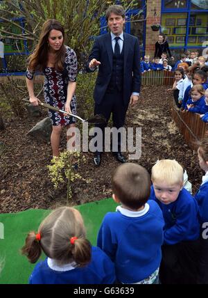 The Duchess of Cambridge plants a willow tree with comedian John Bishop at The Willows Primary School, Wythenshawe, Manchester where she launched a new school counselling programme to help combat the effects of drug and alcohol addiction. Stock Photo