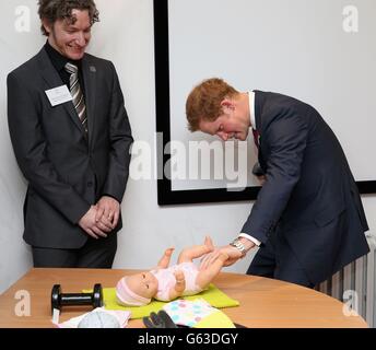 Prince Harry is watched by brain injury survivor Dominic Hurley as he experiences what it is like to have a brain injury as he opens the new headquarters of Headway, the brain injury charity during an official visit to Nottingham. Stock Photo