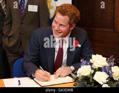 Prince Harry signs a visitors book as he opens the new headquarters of Headway, the brain injury charity during an official visit to Nottingham. Stock Photo