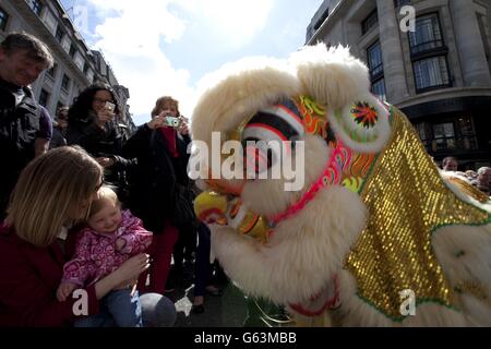 A performance of a traditional Lion dance on Regent Street in central London, bringing nations together with 'InsureandGo' The World On Regent Street'. Stock Photo