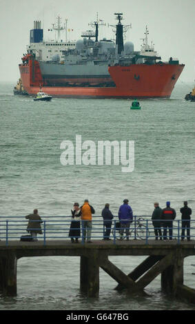 Onlookers watch the arrival of the Royal Navy ship HMS Nottingham on the back of Dutch heavy lifting ship MV Swan at Portsmouth Old Town. *..The battered vessel has been brought back for 26 million of repairs after it sustained hull damage when it ran aground off Australia earlier this year. The Type-42 destroyer hit rocks and holed her hull from bow to bridge at Lord Howe Island in July. Stock Photo