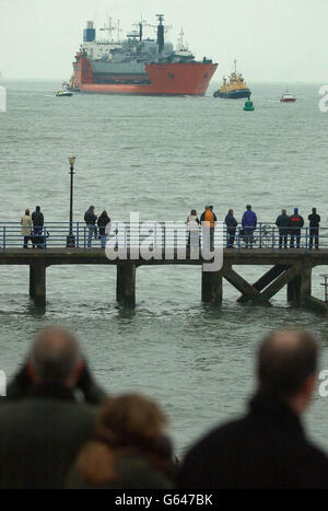 Onlookers watch the arrival of the Royal Navy ship HMS Nottingham on the back of Dutch heavy lifting ship MV Swan at Portsmouth Old Town. *..The battered vessel has been brought back for 26 million of repairs after it sustained hull damage when it ran aground off Australia earlier this year. The Type-42 destroyer hit rocks and holed her hull from bow to bridge at Lord Howe Island in July. Stock Photo